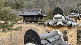 기와지붕과 돌담 사이로 바라본 명농당과 산자락