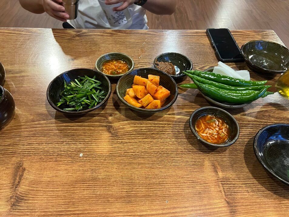 깍두기와 부추, 고추, 새우젓이 놓인 기본 상차림