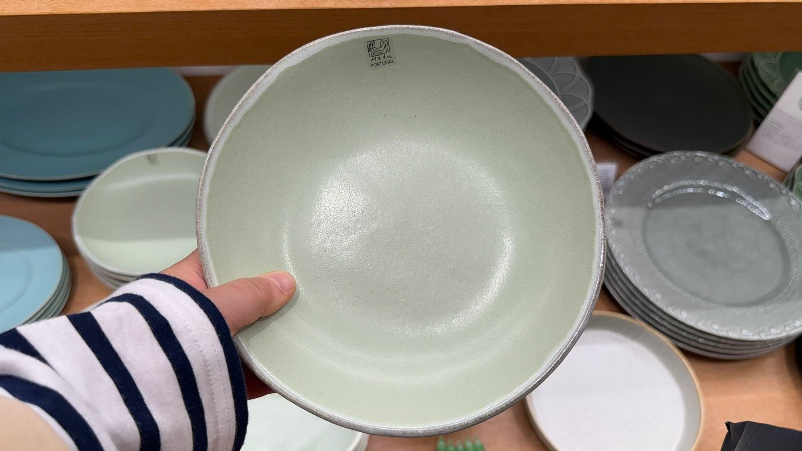 손으로 들어 본 연한 민트색 도자기 접시