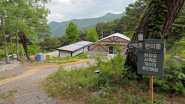 쉼오지캠프 전체 사이트 리뷰|하늘존·산맥존 명당자리 추천 산맥존 편의동으로 가는 길을 안내해주는 입간판